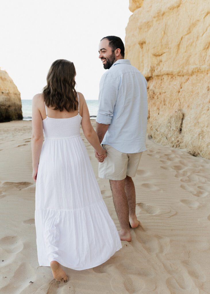 canadian couple walking along beach in the algarve