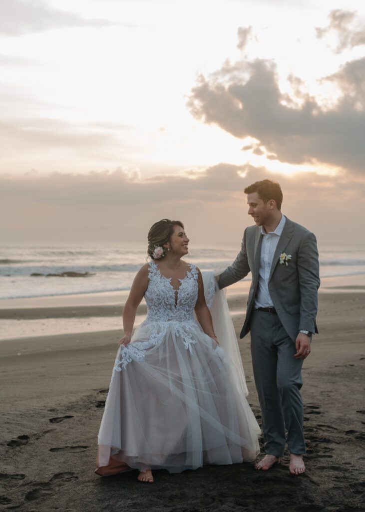 canadian couple walking barefoot on beach in bali
