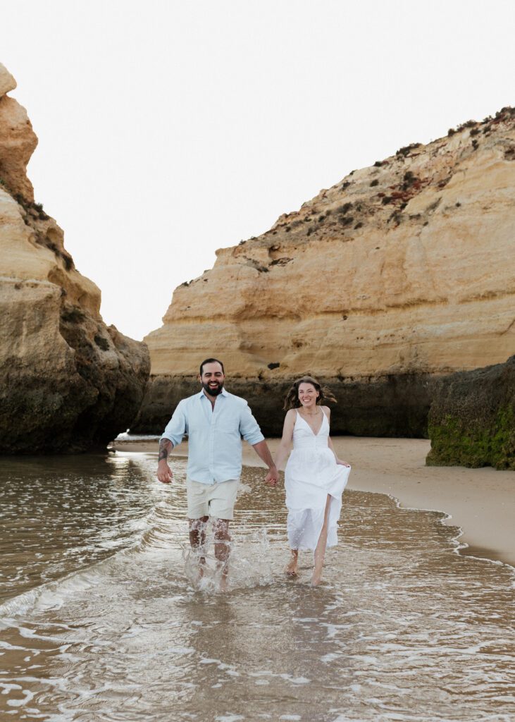 couple running along beach for their beach engagement in the algarve